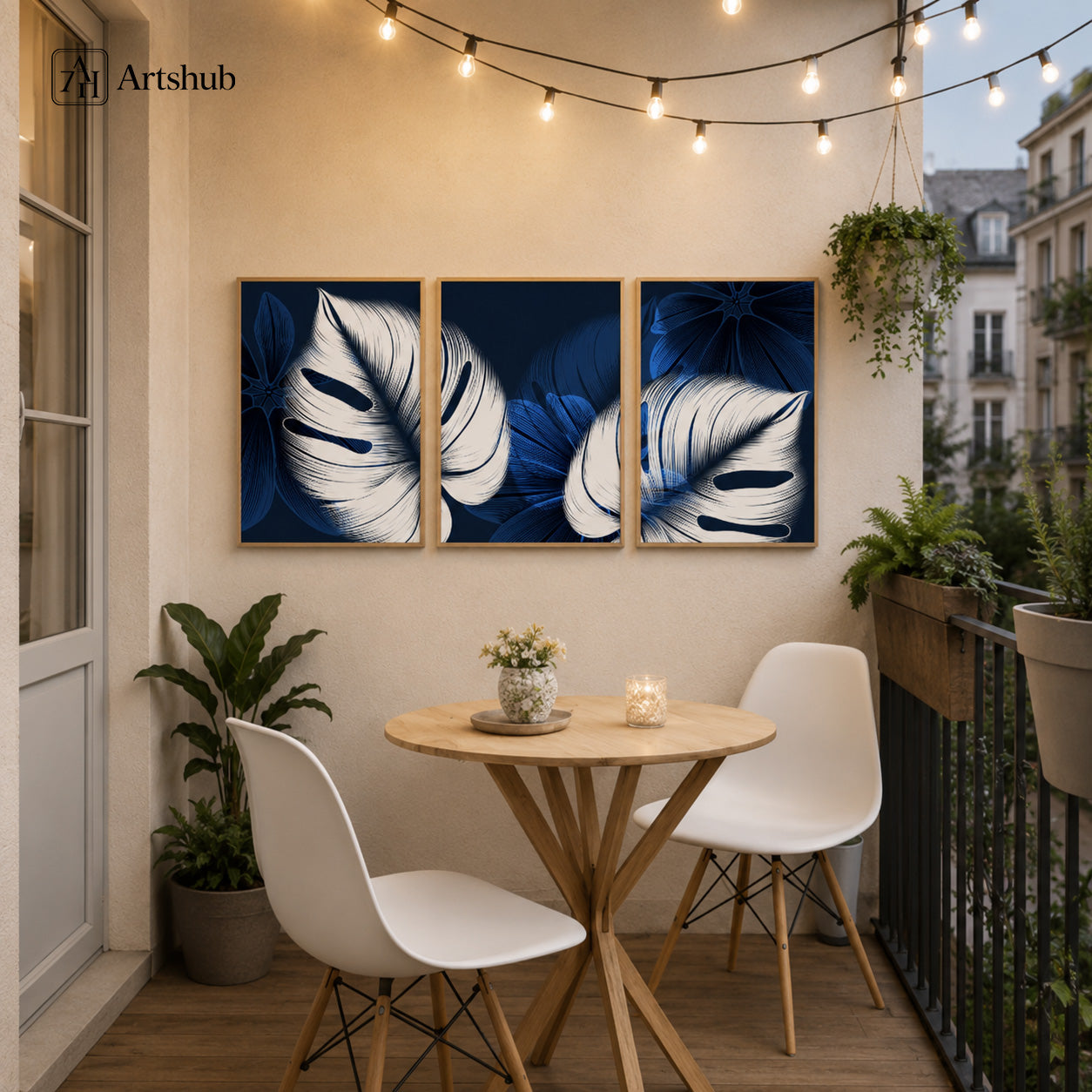 Artshub Navy Blue Monstera Leaf triptych 3 panel framed canvas wall art on balcony wall with string lights round table white chairs and hanging plants — navy blue white oak