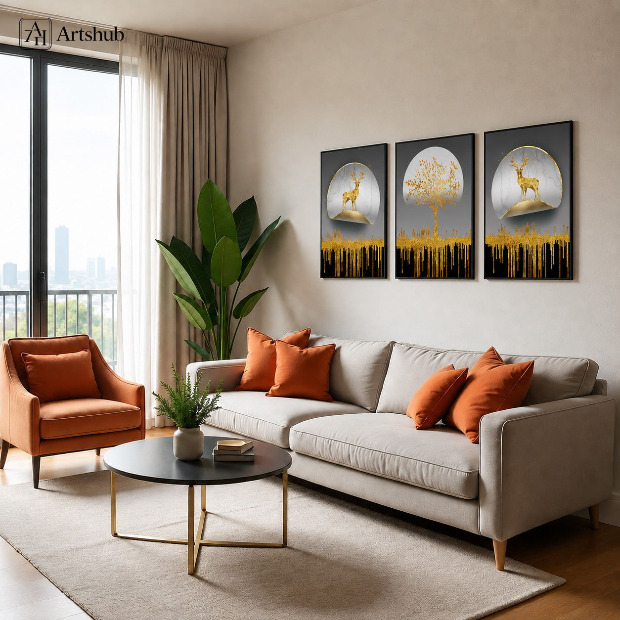 Artshub Golden Nature Moon Deer Tree triptych 3 panel framed canvas wall art in modern beige living room above cream sofa with orange cushions and round black coffee table — gold charcoal grey