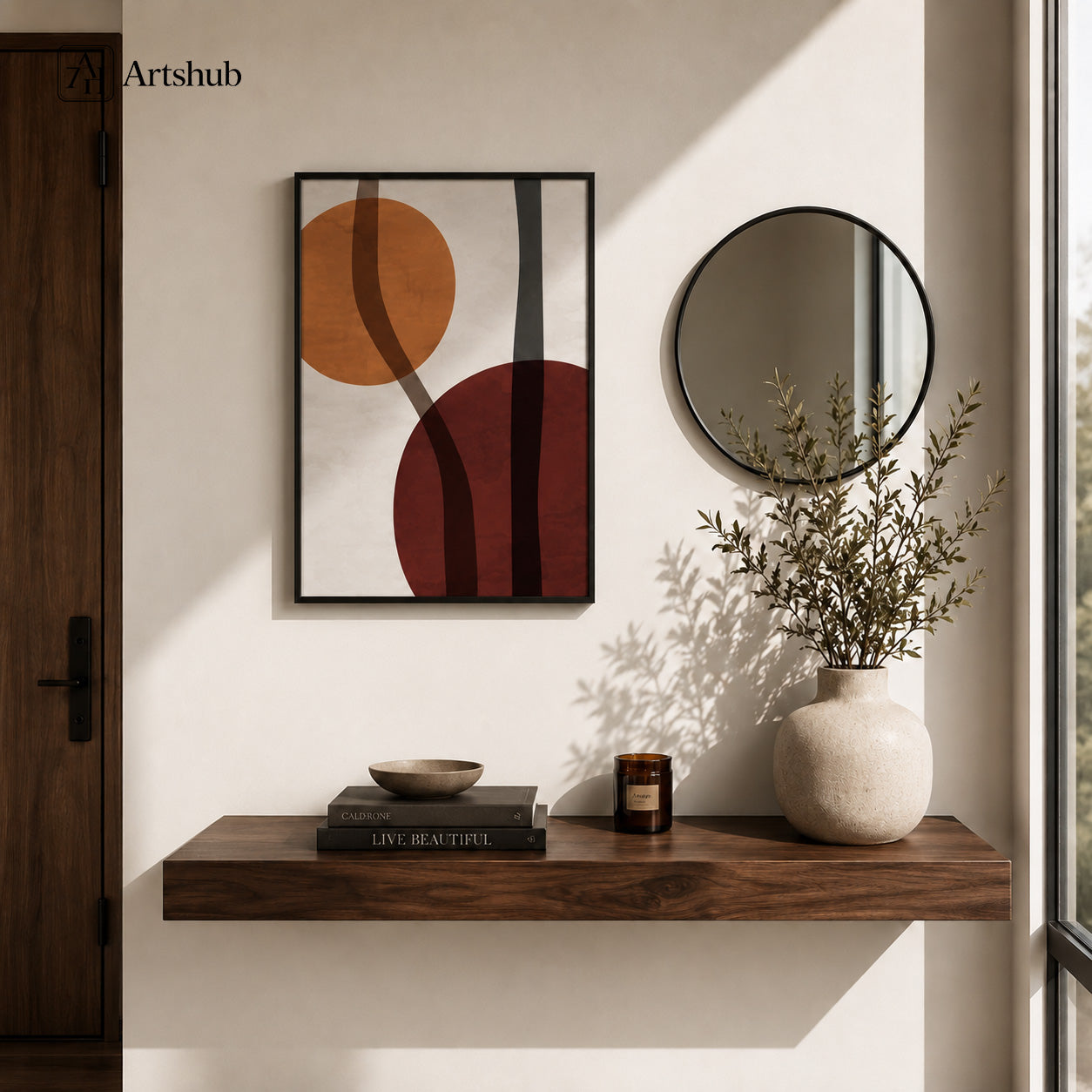 Artshub Art That Elevates Every Space Amber Burgundy Abstract Circles single panel framed canvas wall art in warm entryway above walnut floating shelf with books ceramic bowl candle and round mirror — amber burgundy charcoal matte black frame