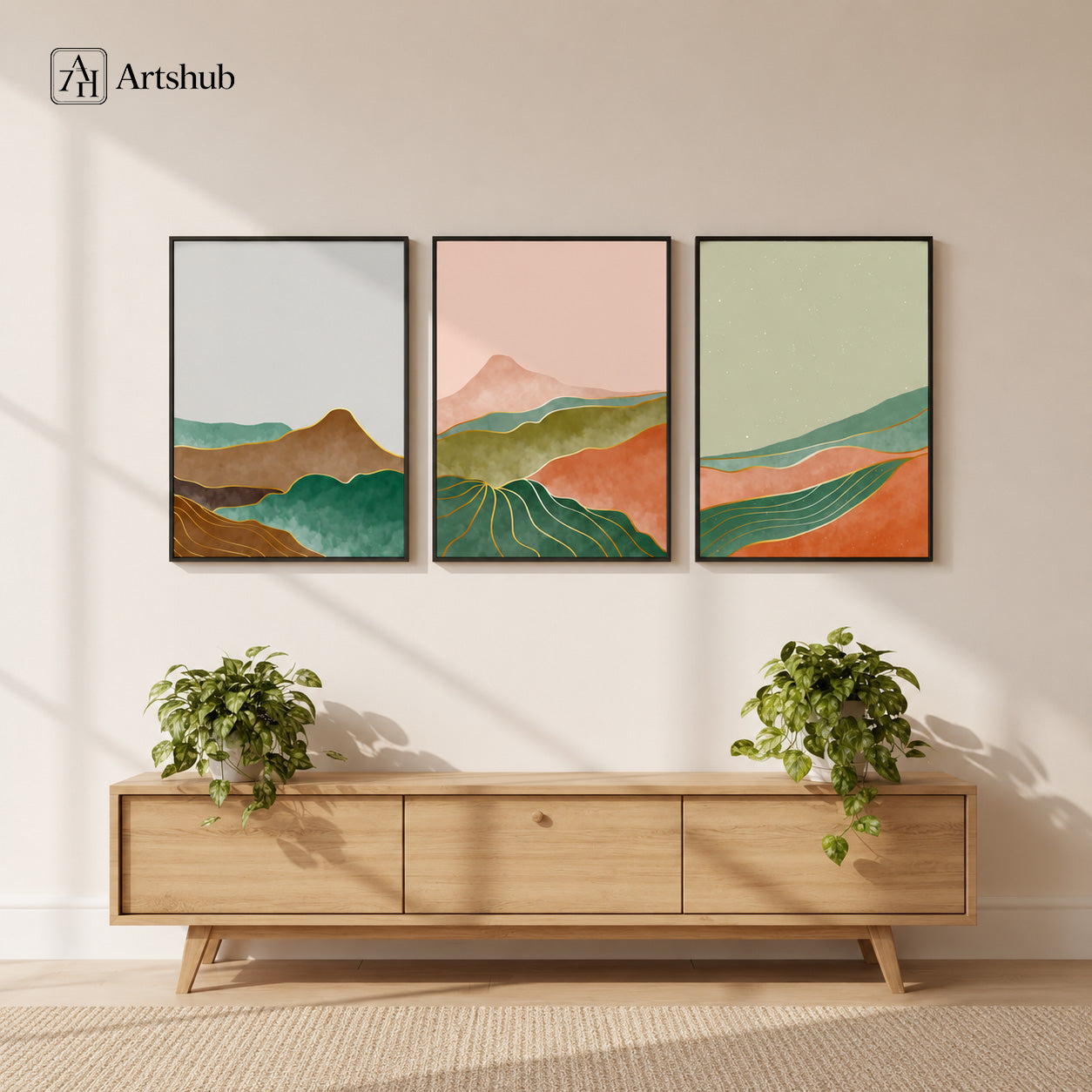 Artshub Curated Landscapes Blush Pink Forest Green Terracotta Mountain Valley triptych 3 panel framed canvas wall art in bright Scandinavian living room above oak TV unit with trailing pothos plants — blush pink green terracotta matte black frame